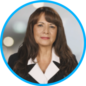 Photo of a woman with long brown hair in a business casual outfit looking at camera.